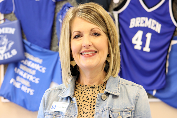 breast cancer survivor with school bulletin board behind her