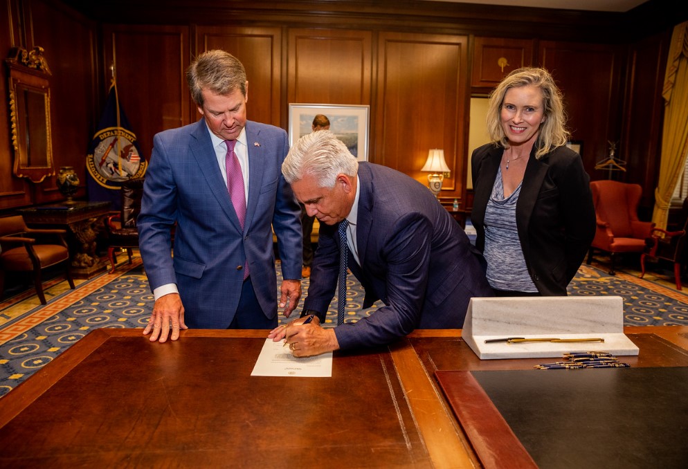 Wayne Senfeld signing paper with Gov. Kemp