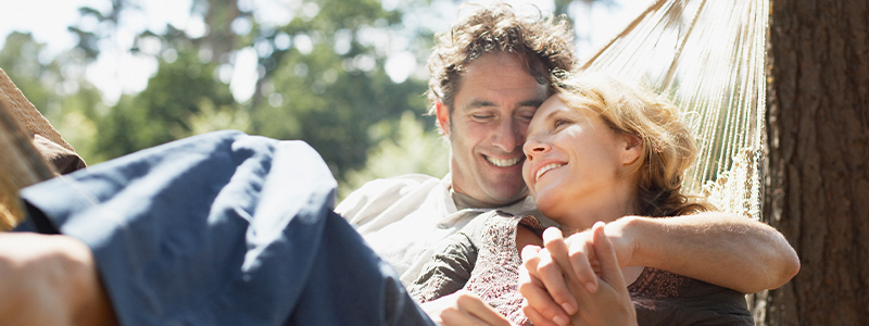 Husband and wife laying in hammock outside