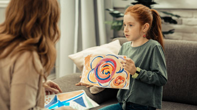 Early teen girl showing her art to her therapist.