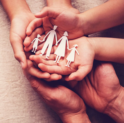 Hands holding a cutout of family.