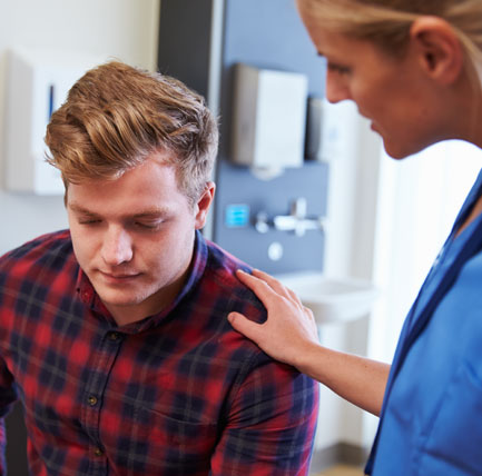 Nurse with hand on shoulder of a male patient