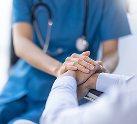 Nurse holding a patients hands